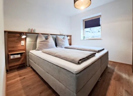 Schlafzimmer mit Boxspringbett in der Ferienwohnung Alpenglück³